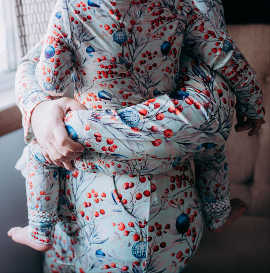 Person wearing a floral patterned outfit sitting by a window.