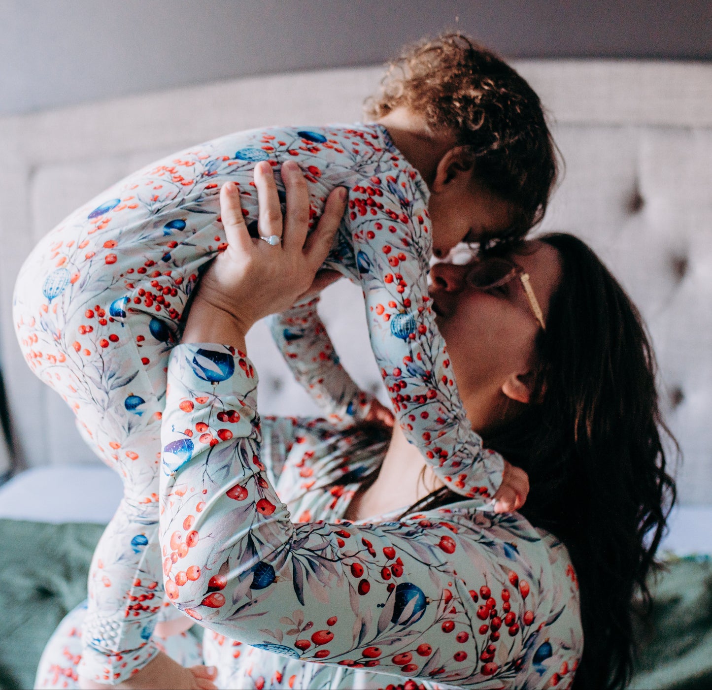 Woman holding a child in pajamas on a bed