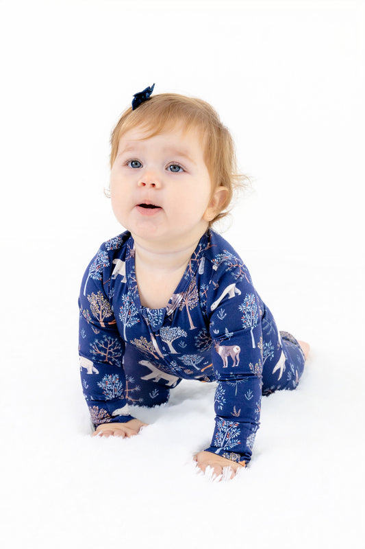 Front view of baby girl wearing Woodland Night modal sleeper with foldover feet