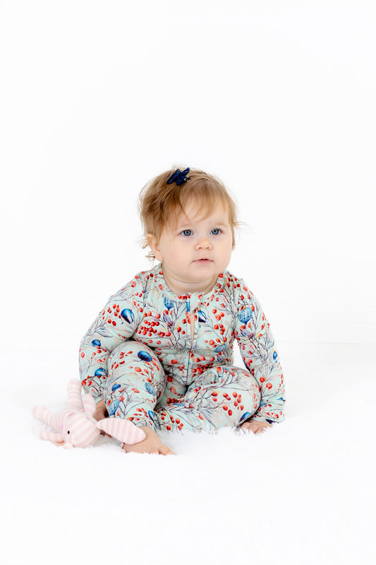 Front view of baby girl wearing Frosted Berry modal romper with foldover feet