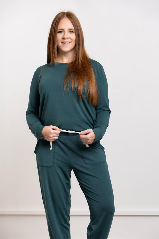 Woman wearing women modal pajama set, evergreen crew neck and jogger pants, showcasing stylish and comfortable sleepwear.
