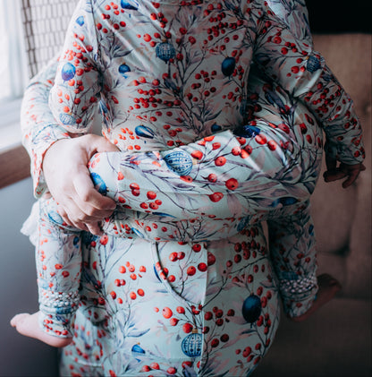 Person wearing a floral patterned outfit sitting by a window.