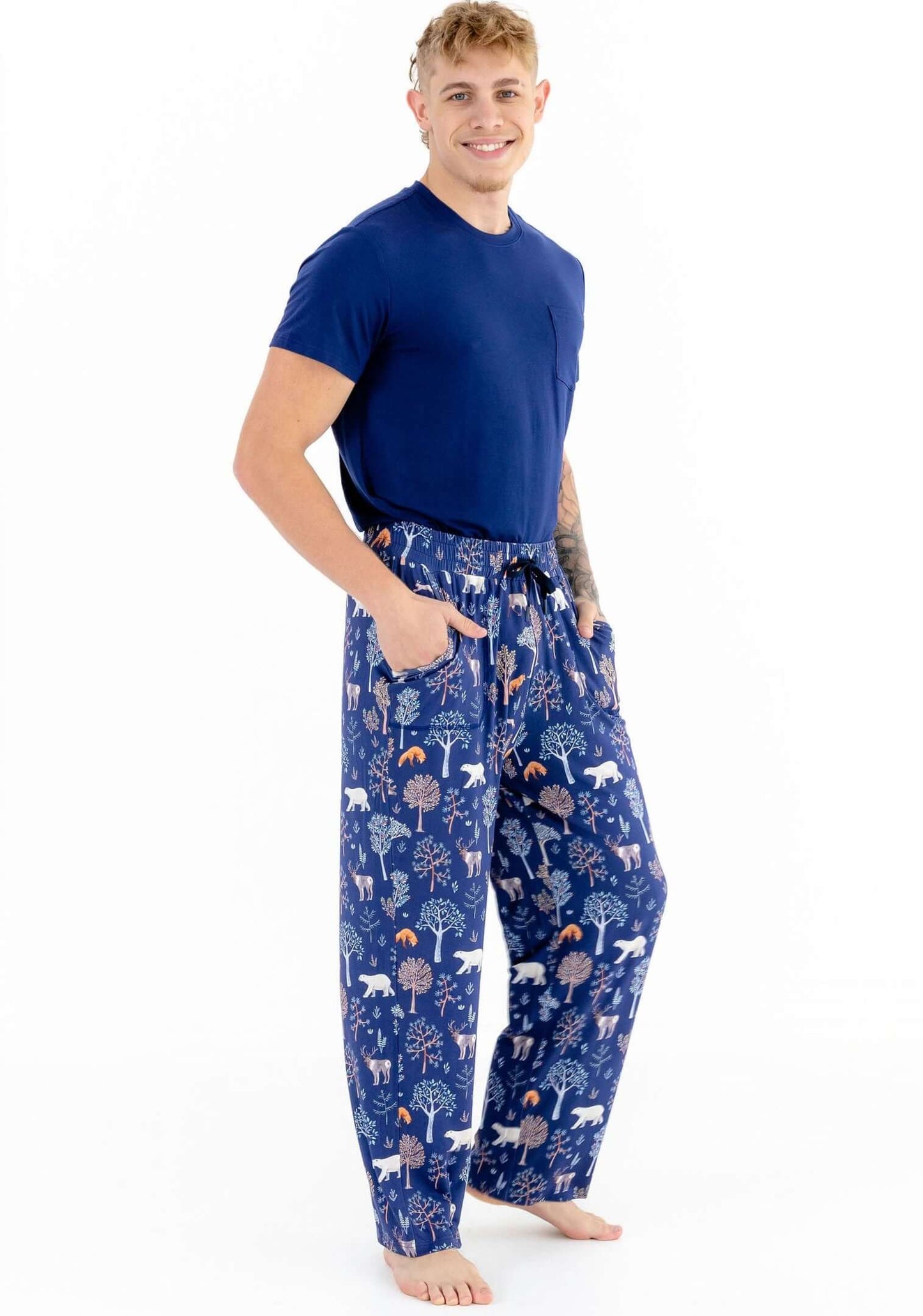 Man wearing blue pajama pants with animal pattern on a white background
