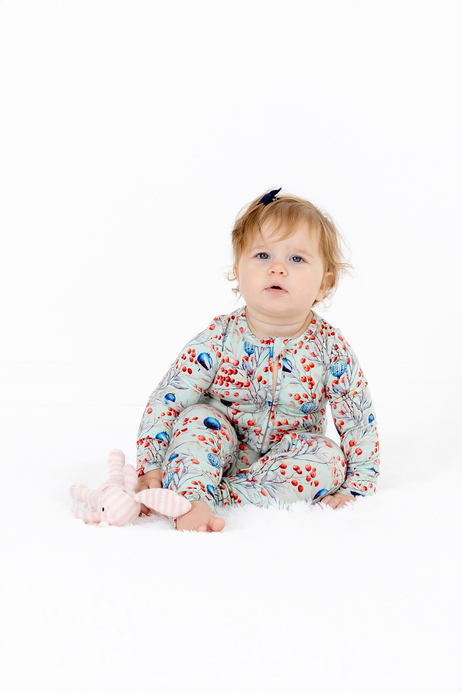 Baby girl sitting in baby modal convertible romper pajama – Frosted Berry Christmas print