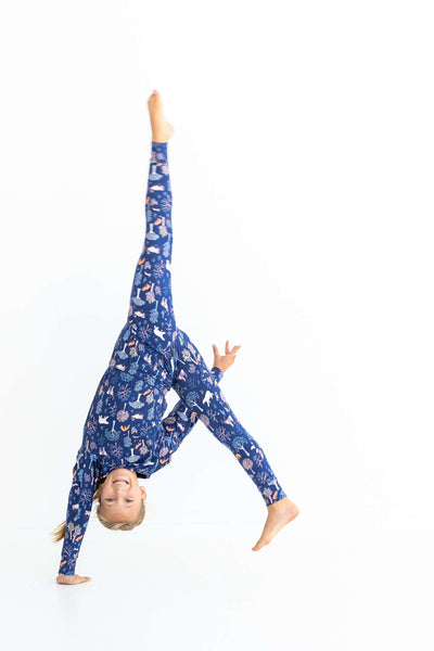 Girl doing a cartwheel in kids pajama set – Woodland Night print shows soft, stretchy fit and freedom to move