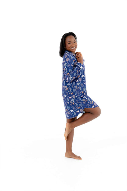 Smiling woman in a blue floral Woodland Night women nightshirt long sleeve, showcasing comfort and style.
